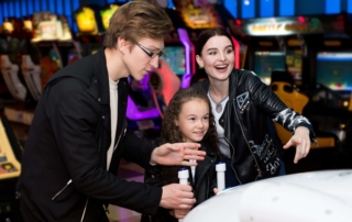 A father, mother and child playing at arcades in Oregon.