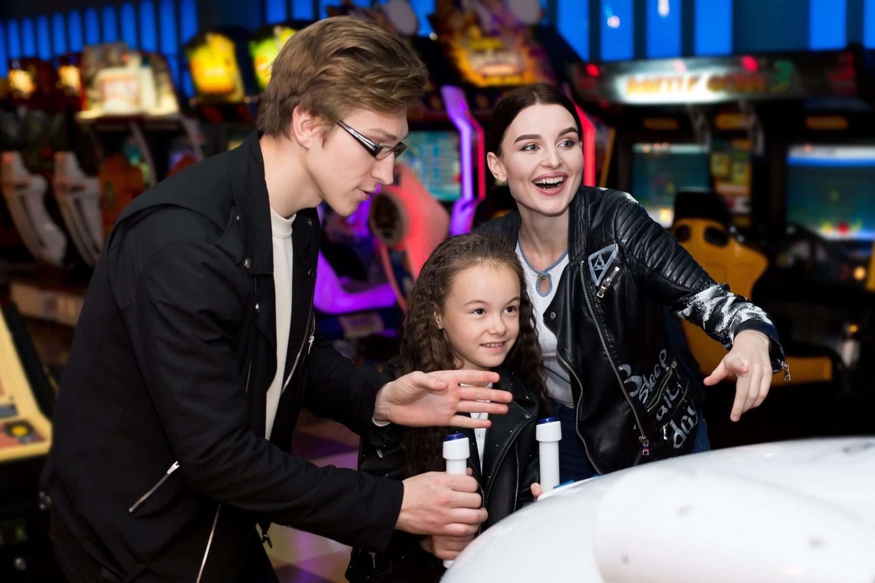 A father, mother and child playing at arcades in Oregon.
